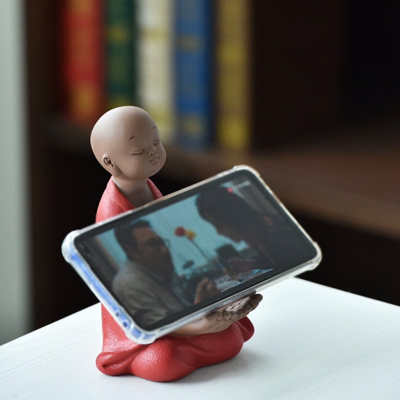 Little monk with a phone stand